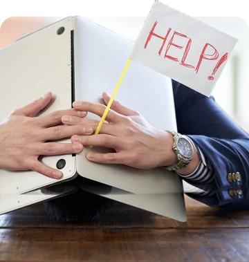 Professionelle Website erstellen lassen für mehr Qualität und Sichtbarkeit Geschäftsperson unter Laptop mit „Help“-Fahne – braucht eine professionelle und hochwertige neue Website